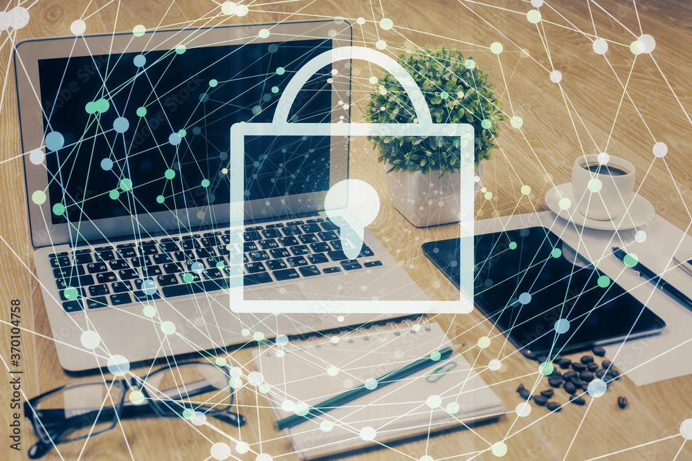 Double exposure of desktop with computer and lock icon hologram. Concept of data safety. Double exposure of desktop with computer and lock icon hologram. Concept of data safety.