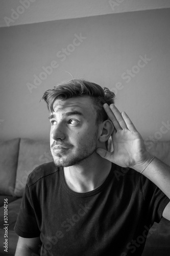 Black and White, Young white man with black shirt over green wall listening something