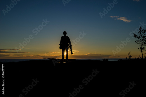 A man with a camera on the background of the sunset. Journey 