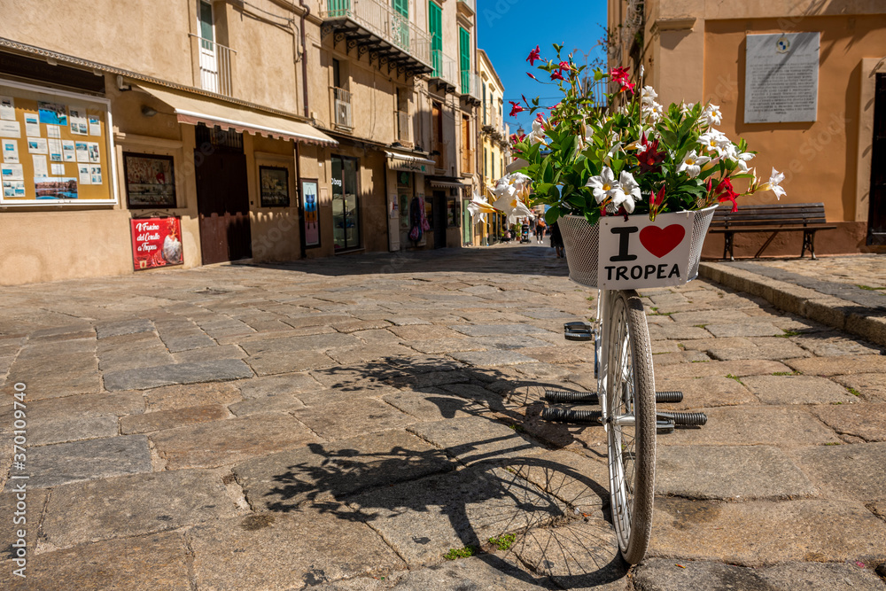 Urocza uliczka w Tropea, rower z tabliczką będący miejscem spotkań młodzieży - obrazy, fototapety, plakaty 