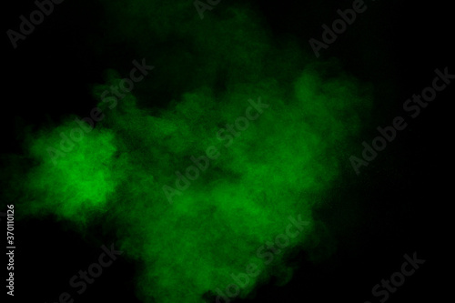 Abstract green powder explosion on black background.Freeze motion of green dust cloud.