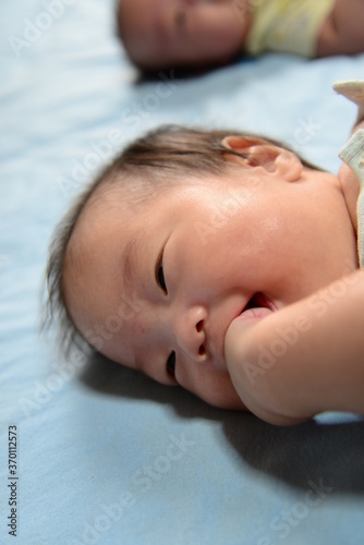 ごきげんで口に手を入れる赤ちゃん