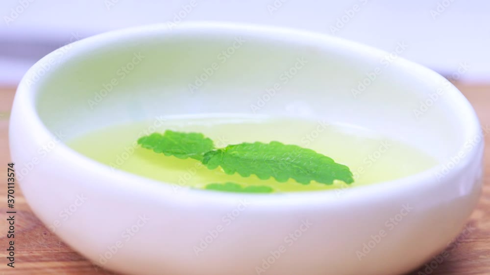 The mint leaf is falling into the oil. Cooking the sauce. The chef is cooking mint sauce and olive oil. Someone's putting mint pliers in the butter. The mint leaf is falling into the oil. Cooking the sauce. The chef is cooking mint sauce and olive oil. Someone's putting mint pliers in the butter.