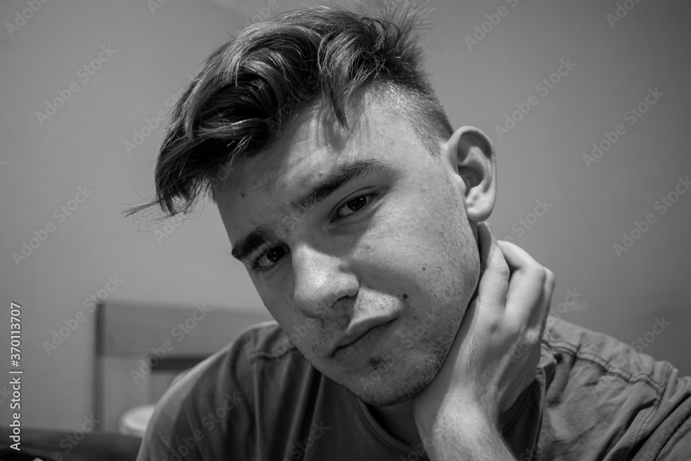 young-male-with-light-brown-hair-having-neck-pain-and-holding-his-hand