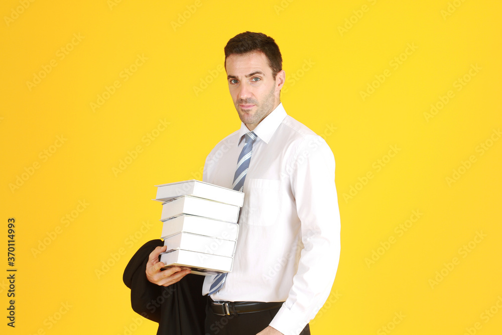 Smart businessman in suit and white shirthand holding document books isolated on yellow background. Smart businessman in suit and white shirthand holding document books isolated on yellow background.