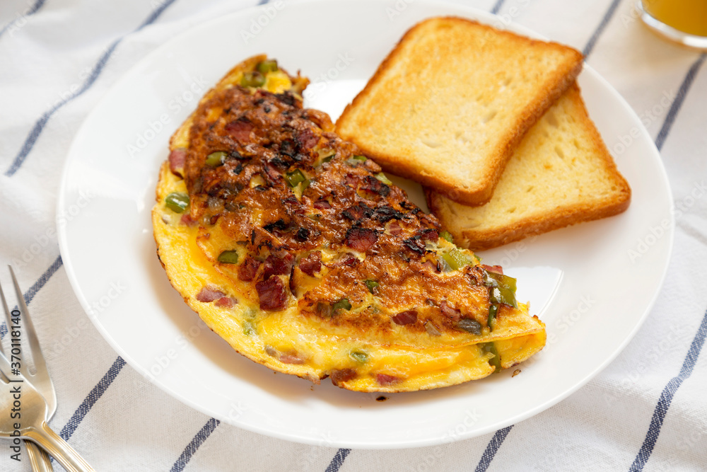 Homemade Denver Omelette on a white plate on cloth, side view. Flat lay, top view, from above.