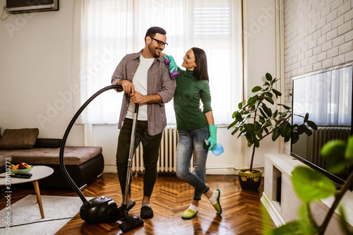 Young happy couple is cleaning their apartment. photo