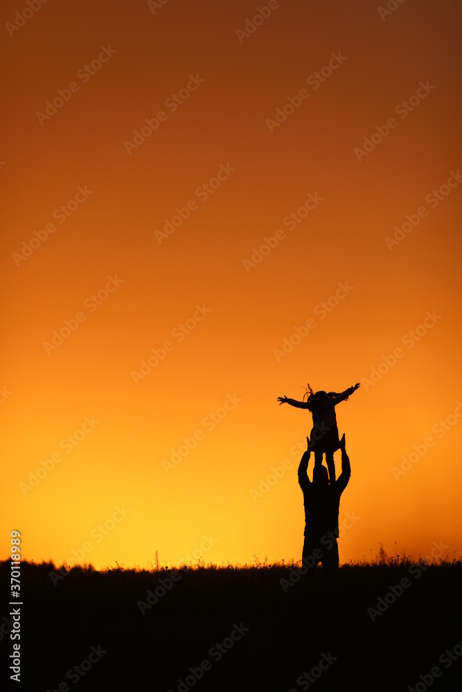 
beautiful sunset orange sky girl and dad happiness holding a girl in his arms family