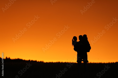  beautiful sunset orange sky girls and dad happiness holding girls in his arms family