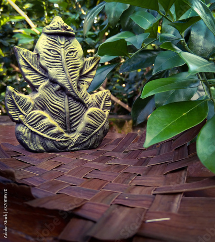Portrait picture of lord Ganesha sculpture with leaves in the background.
Lord Ganesha is one of the most important gods in Hindu religion and is also known as 'Ganpati Bappa