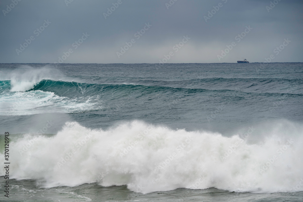 Bib waves rolling into the beach, massive surf day