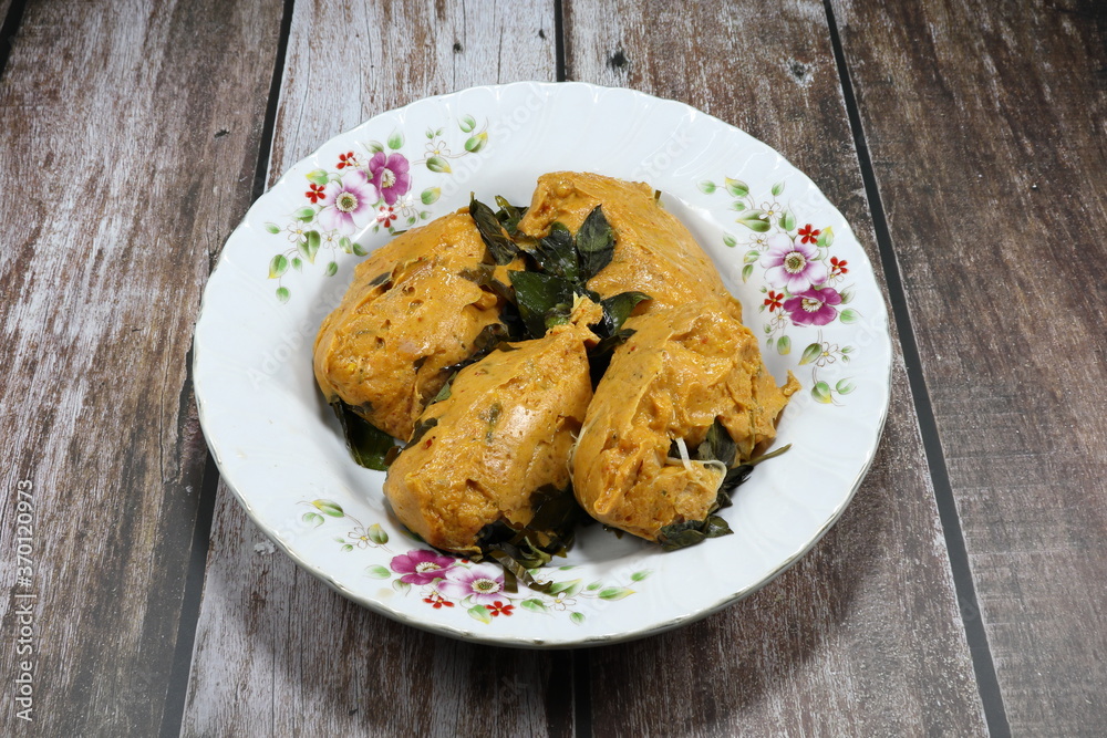 Traditional Steamed fish mixed with curry paste and coconut milk on the plate. Famous Thai local spicy seafood in Asia restaurant. Traditional Steamed fish mixed with curry paste and coconut milk on the plate. Famous Thai local spicy seafood in Asia restaurant.