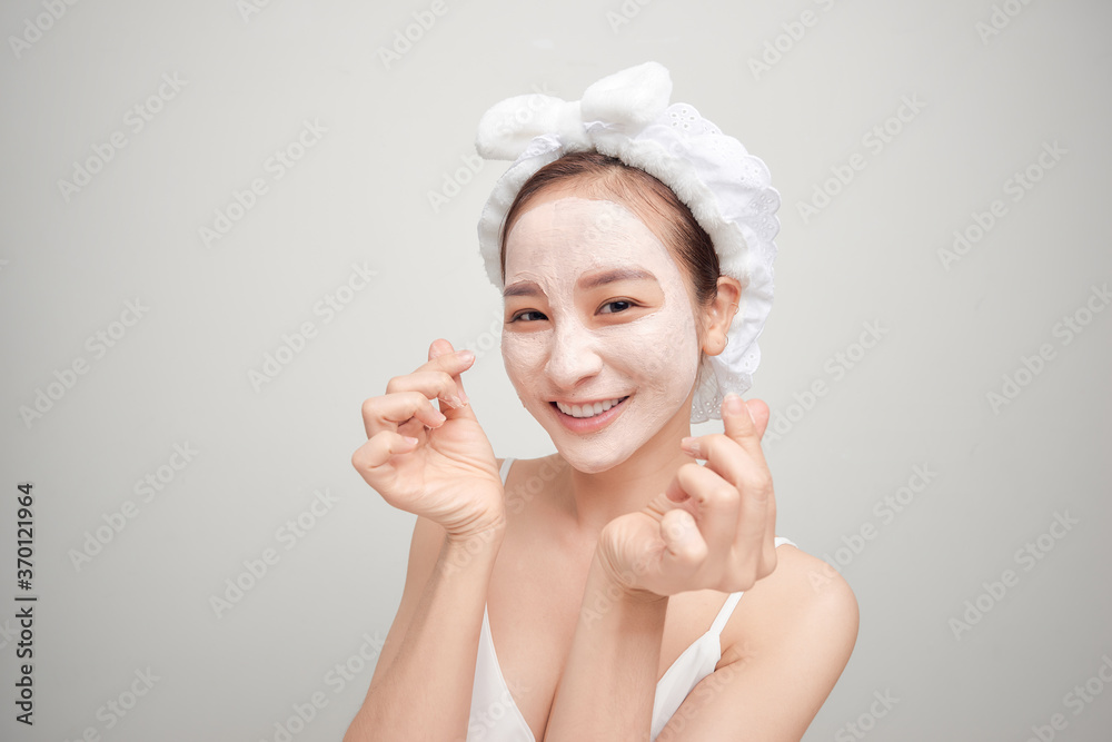 Woman on a white background clean face cream on face towel in hair on head Woman on a white background clean face cream on face towel in hair on head