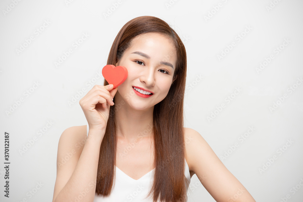 Portrait of a happy young woman holding paper heart isolated over white background. Portrait of a happy young woman holding paper heart isolated over white background.
