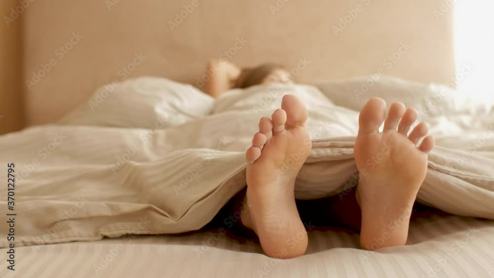 young woman awakening,sipping fingers on legs and stand up from bed, girl resting lying, morning routine young woman awakening,sipping fingers on legs and stand up from bed, girl resting lying, morning routine