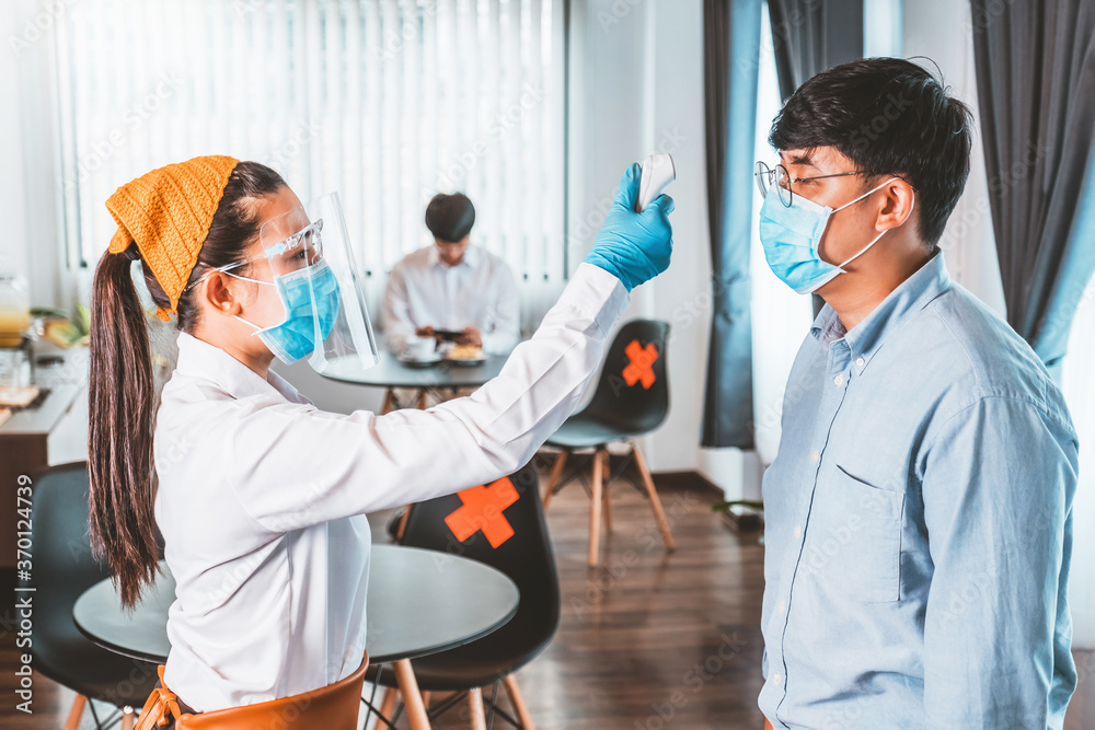 Obraz premium Asian waitress wear protective face mask explain and Using alcohol gel clean wash hand scan customer temperature