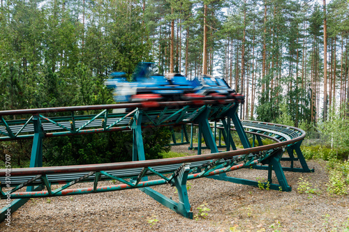 Ride Roller coaster in motion in amusement park at summer day photo