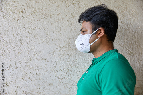 well built adult male wearing N 95 Respirator, Profile shot