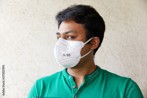Adult Indian Male looking into the camera while wearing a respirator