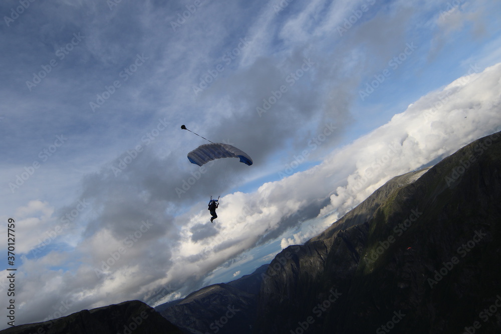 Fototapeta premium Skydivers over snowy mountains in Norway