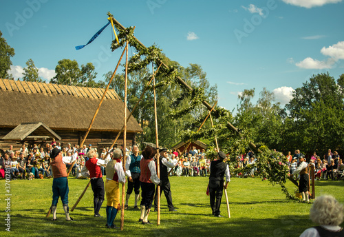 Raising of a midsummer pole duringa a traditional celebration of swedish midsummer in the small town of Skara photo