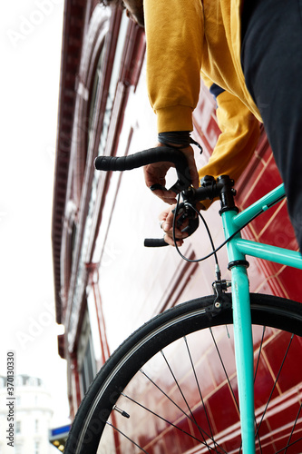 Millennial on bike in urban area. Front wheel fixed gear bike.