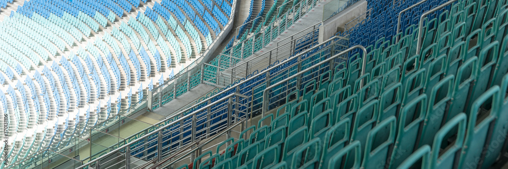 Fototapeta premium Panoramic image. Empty seats at the stadium without the spectators due to the Corona Virus Covid-19