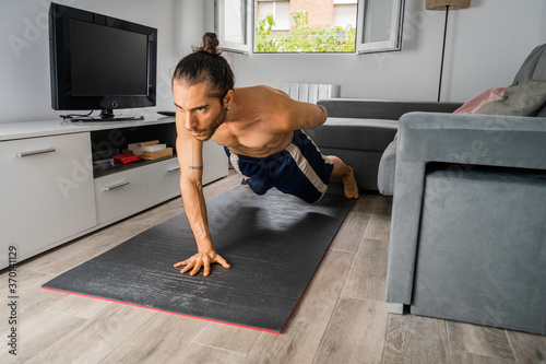 Tableau sur toile hombre joven en buena forma física, con moño, sin camiseta, y con pantalón corto