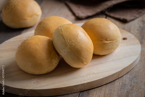 Bread roll or bun on wooden board