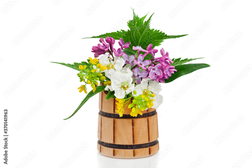 Hawthorn, lilac and bittercress flowers with leaves in a wooden vase isolated on a white background. 