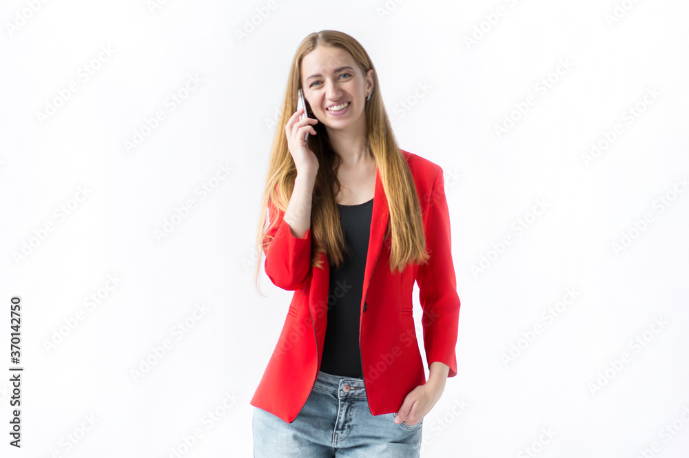 Portrait of a smiling girl who is standing and talking on the phone on a white background Portrait of a smiling girl who is standing and talking on the phone on a white background