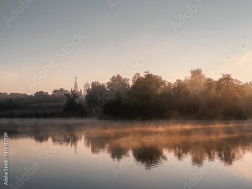 Beautiful morning landscape with fog over the lake