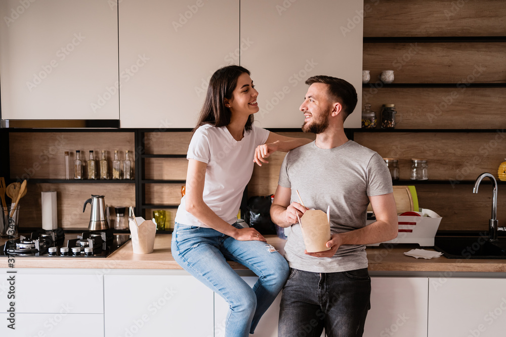 Beautiful young couple has a good time together at home while eating Chinese food Beautiful young couple has a good time together at home while eating Chinese food