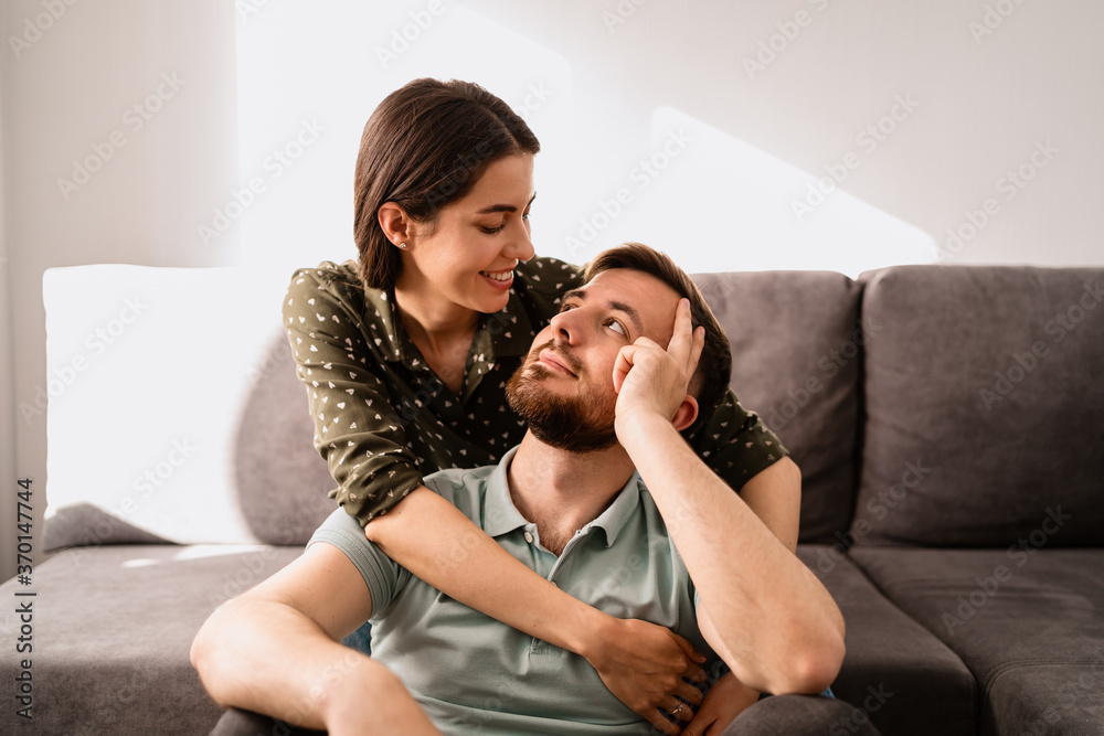 Close up happy couple together smiling and hugging on the sofa Close up happy couple together smiling and hugging on the sofa
