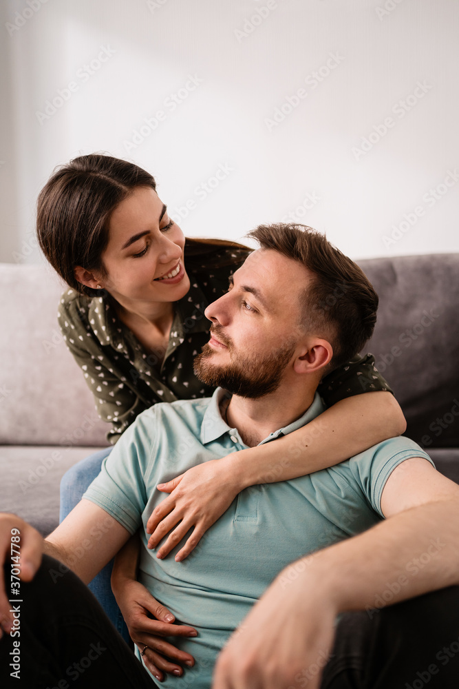Close up happy couple together smiling and hugging on the sofa Close up happy couple together smiling and hugging on the sofa
