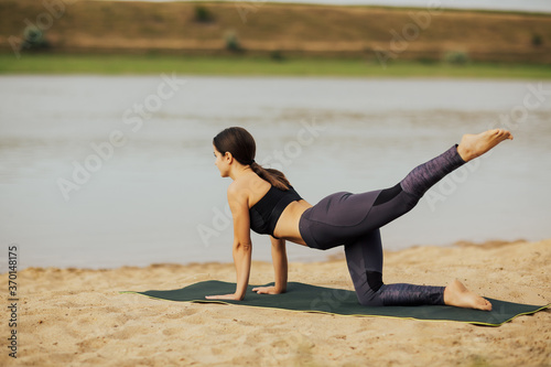 Young beautiful woman with a slim figure goes in for sports at beach. Fitness, sport and healthy lifestyle concept.