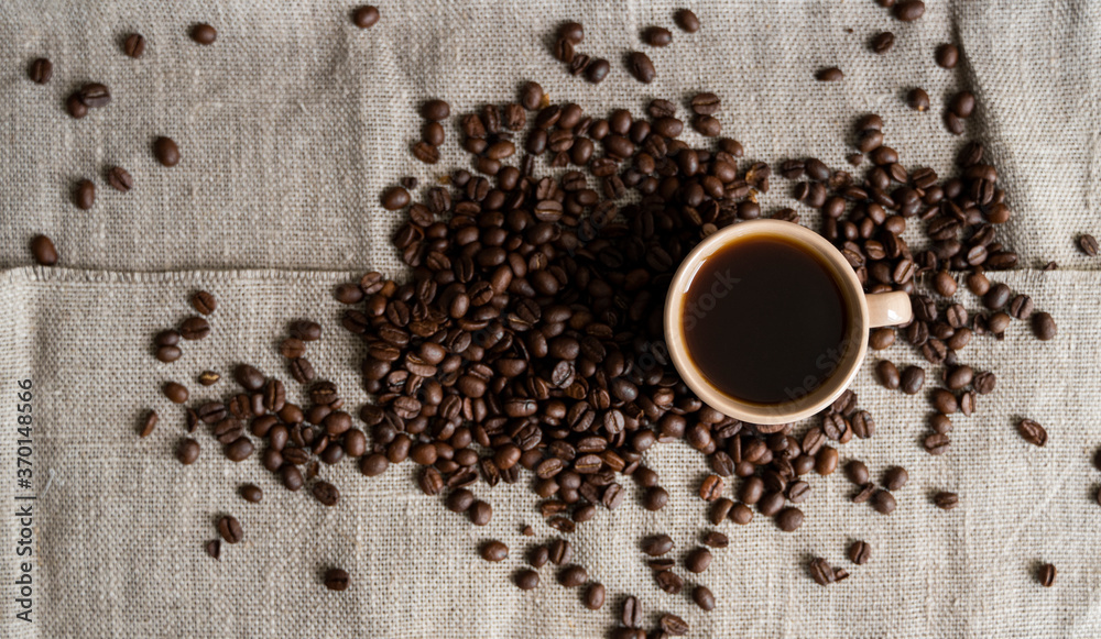 Coffee cup with roasted coffee beans on linen background. Mug of black coffe with scattered coffee beans. Fresh coffee beans. Coffee cup with roasted coffee beans on linen background. Mug of black coffe with scattered coffee beans. Fresh coffee beans.