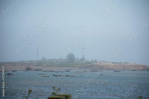 A cross in the mist over the bay