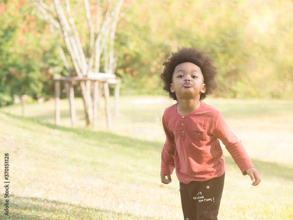 Cute little mix race African boy making funny face while playing in the park. Cute little mix race African boy making funny face while playing in the park.