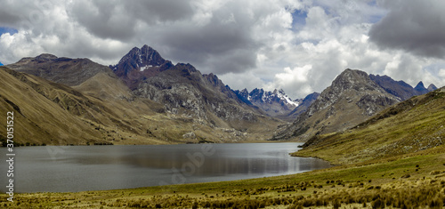 Landscape with moutains, lake, green grass and a moody sky in a hike in Huaraz, Peru © José Rego
