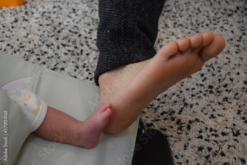 生後36日の赤ちゃんとパパの足  © noranoramona