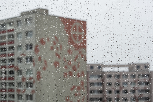 Block of flats in the rain through the raindrops
