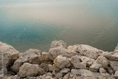 White rocky stones washed by clean water with copy space