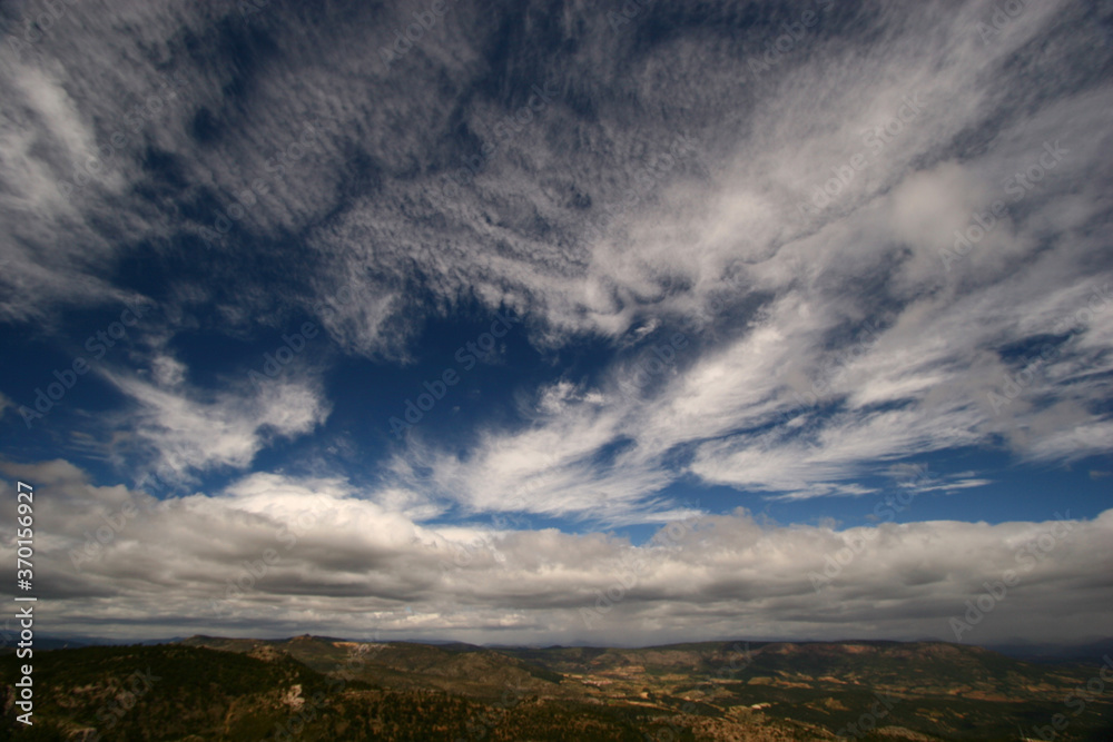 Cielo nuboso sobre la Sierra del Segura, desde la Sierra de la Muela en Moratalla, Murcia, España. Nubes bajas y altas, estratocúmulos y cirros. Cielo nuboso sobre la Sierra del Segura, desde la Sierra de la Muela en Moratalla, Murcia, España. Nubes bajas y altas, estratocúmulos y cirros.