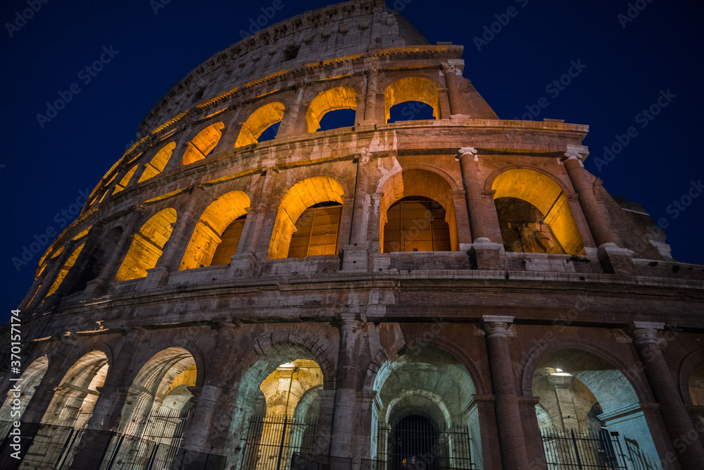 The monumental Colosseum at night, the largest oval Amphitheatre built by the Flavian dynasty in the centre of Rome, just east of the Roman Forum, an iconic symbol of the Roman Empire, Rome, Italy.
