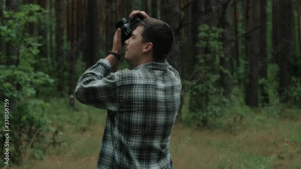 Male photographer is taking photographs in a forest Male photographer is taking photographs in a forest