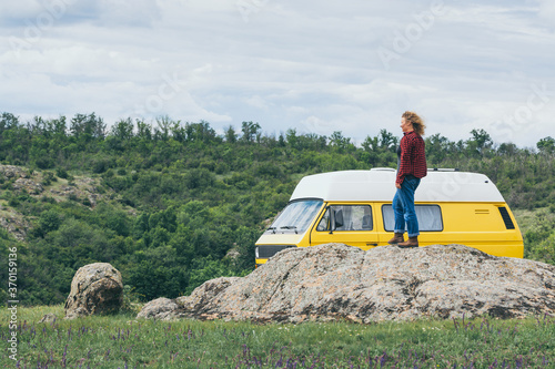 Young blonde woman travelling by campervan though the countryside photo