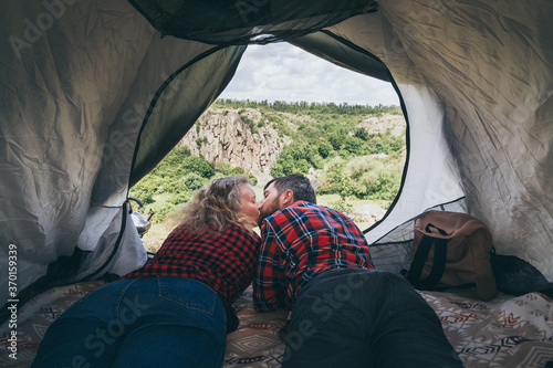 Young couple camping in a tent in the mountains