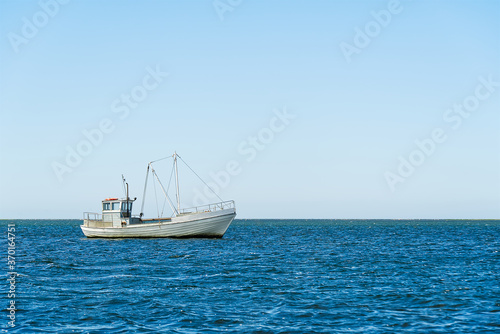 Old Traditional for baltic sea or scandinavian countries Vintage fishing boat in sea. minimalist shot.