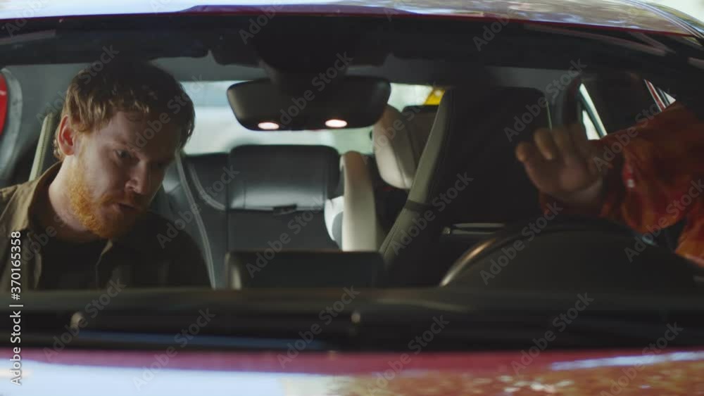 Two young happy men getting into parents car ready for drive